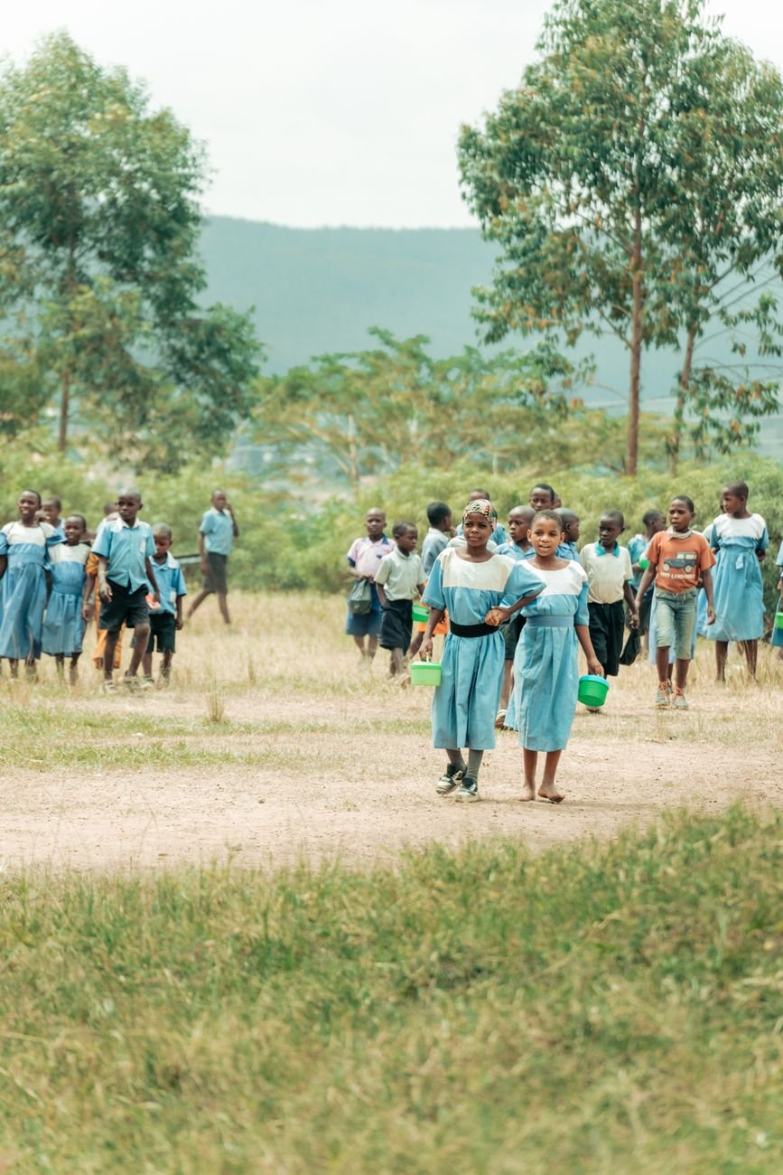 Children in school uniforms walking to class, representing the Foundation's education mission